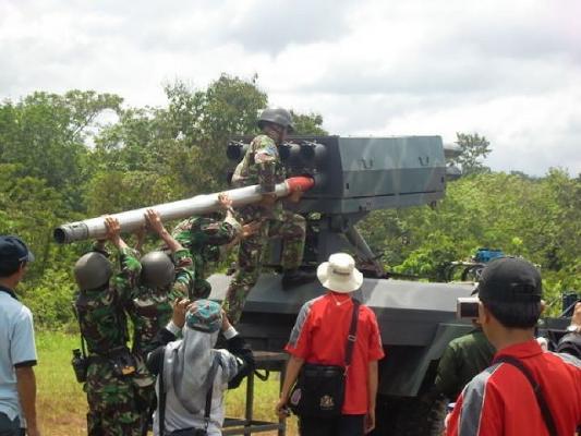 Солдаты индонезийской армии заряжают НУРС R-Han 122 калибра 122 мм в пакет направляющей артиллерийской части боевой машины_on_MLRS